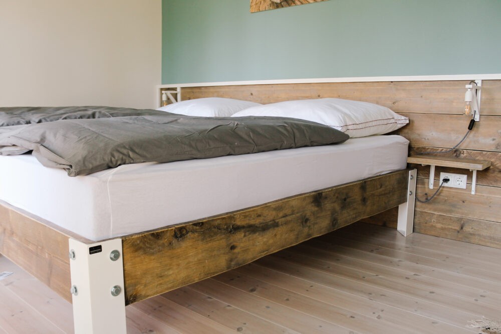 Bett aus Altholz mit stahlbeschlägen.