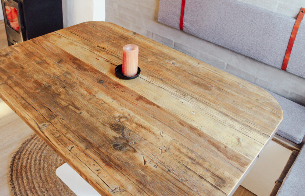Tischplatte aus Altholz mit abgerundeten Ecken.