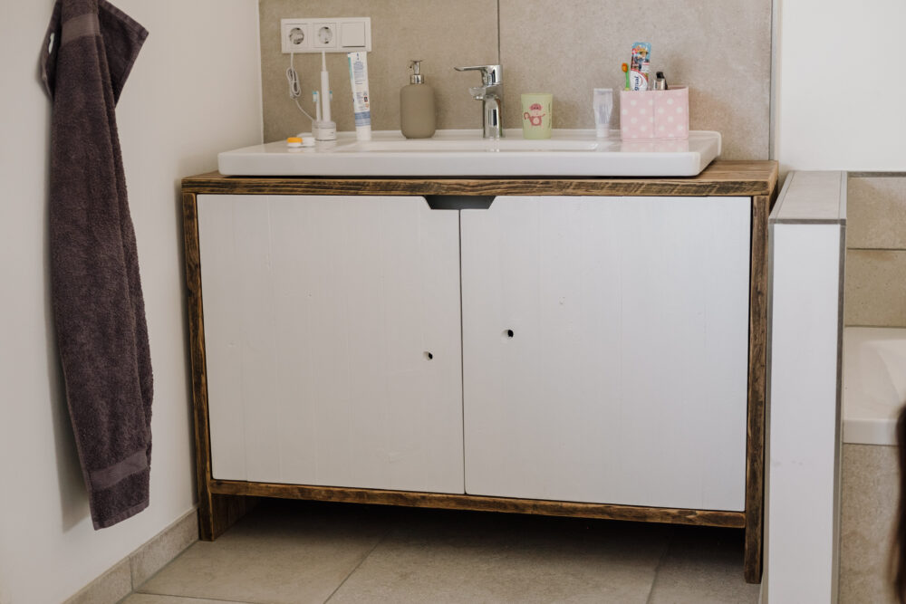 Mit unserem Waschtisch aus recyceltem Gerüstholz namens Jenske holst du dir eleganten Stauraum in dein Badezimmer.